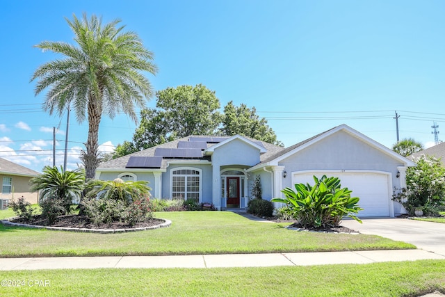 ranch-style house featuring a garage, solar panels, and a front lawn