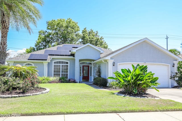 ranch-style house featuring a front yard, a garage, and solar panels