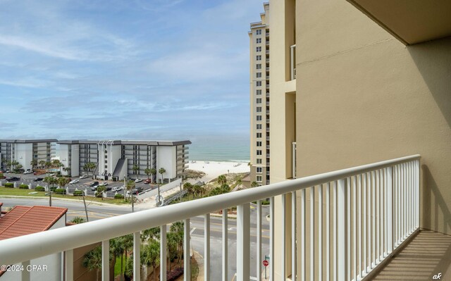 balcony with a water view and a view of the beach