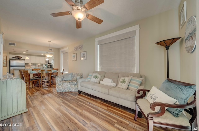 living room with ceiling fan and light hardwood / wood-style flooring