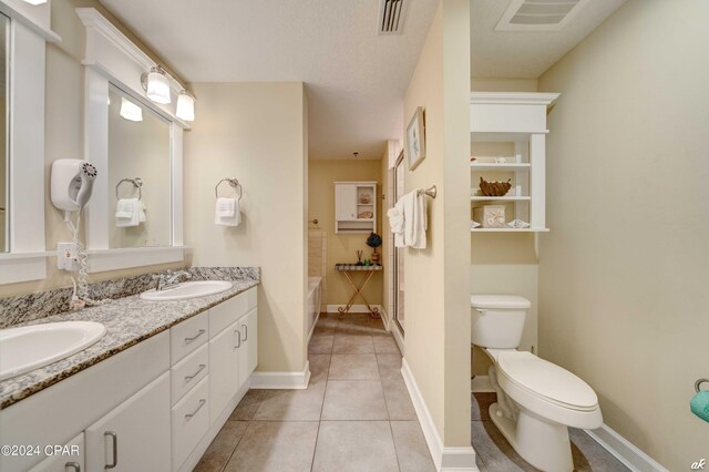 bathroom featuring tile patterned flooring, vanity, toilet, and a shower with shower door