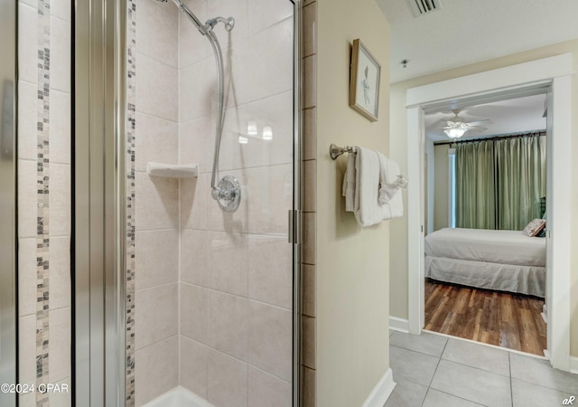 bathroom with hardwood / wood-style flooring, ceiling fan, and an enclosed shower