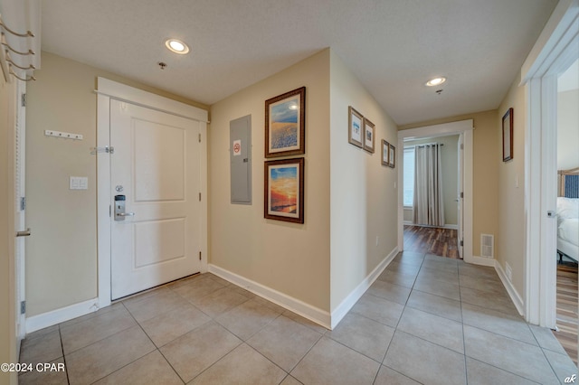 foyer entrance with electric panel and light tile patterned floors