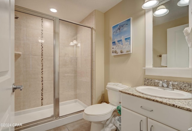 bathroom with walk in shower, tile patterned floors, vanity, and toilet