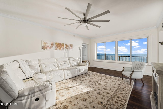 living room featuring ceiling fan, a water view, ornamental molding, and dark hardwood / wood-style floors