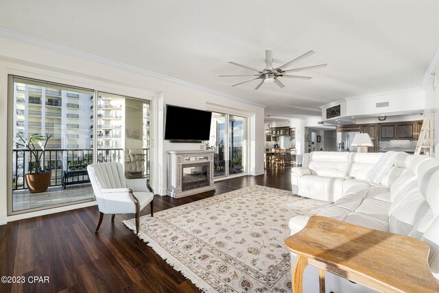 living room featuring hardwood / wood-style flooring, crown molding, and ceiling fan