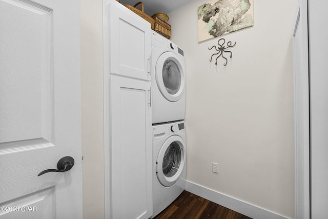 washroom featuring stacked washer / drying machine and dark wood-type flooring