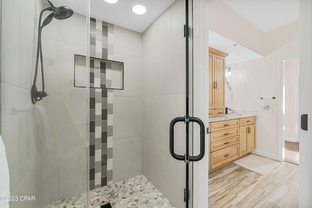 bathroom featuring hardwood / wood-style flooring, walk in shower, and vanity