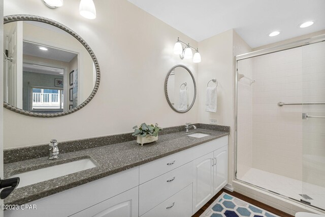 bathroom featuring dual bowl vanity and an enclosed shower