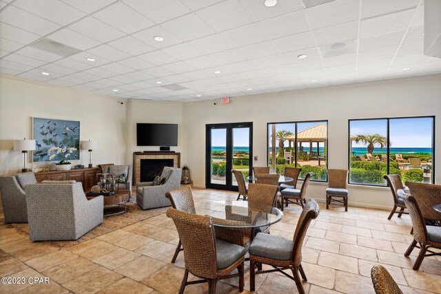 dining area with a fireplace, a healthy amount of sunlight, and light tile patterned floors