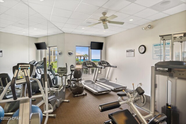 gym featuring ceiling fan and a paneled ceiling