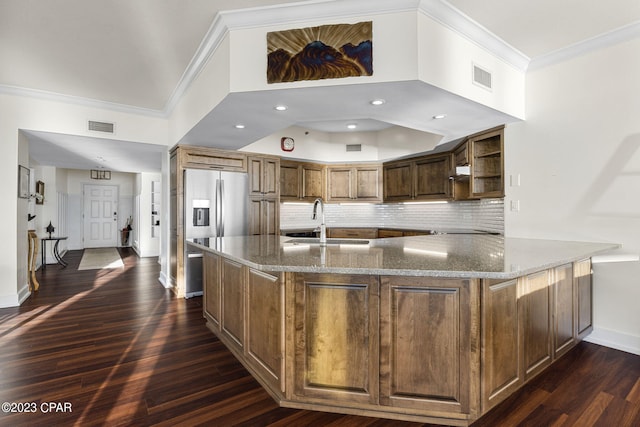 kitchen featuring decorative backsplash, dark hardwood / wood-style floors, and dark stone counters