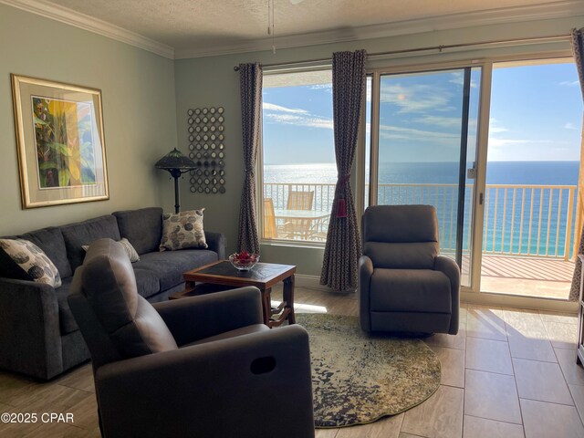 living room featuring a textured ceiling, a water view, ceiling fan, and ornamental molding