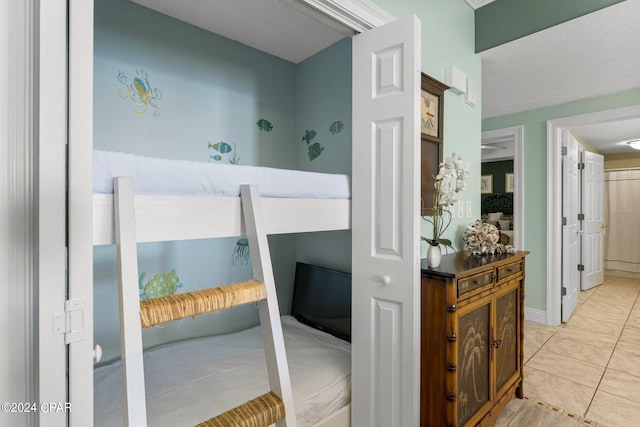 bedroom featuring light tile patterned flooring and connected bathroom