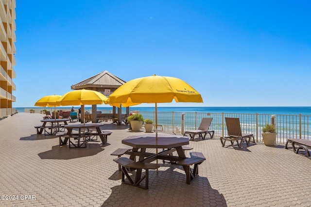 view of community featuring a water view and a beach view