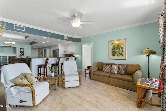 living room featuring a textured ceiling, ceiling fan with notable chandelier, and ornamental molding