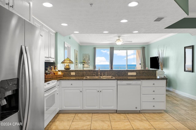 kitchen with ceiling fan, sink, dark stone countertops, white appliances, and white cabinets