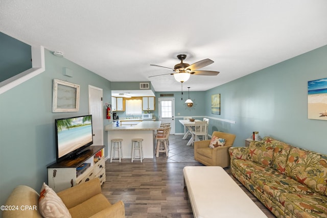 living room featuring dark hardwood / wood-style floors and ceiling fan