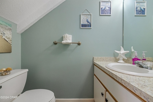 bathroom with oversized vanity, toilet, and a textured ceiling