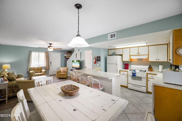 dining space featuring sink, ceiling fan, and light tile floors