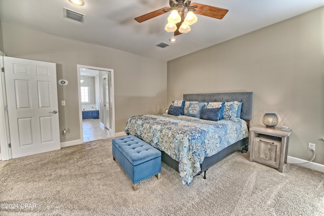 carpeted bedroom with visible vents, connected bathroom, baseboards, and ceiling fan