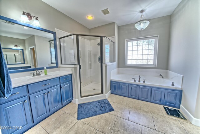 bathroom featuring a chandelier, vanity, plus walk in shower, and tile patterned flooring