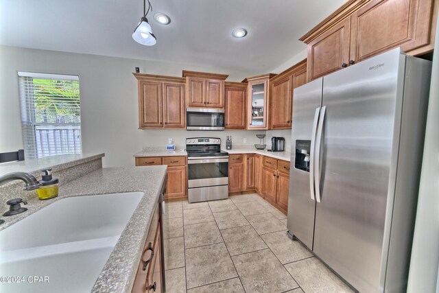 kitchen featuring appliances with stainless steel finishes, sink, decorative light fixtures, and light tile patterned floors