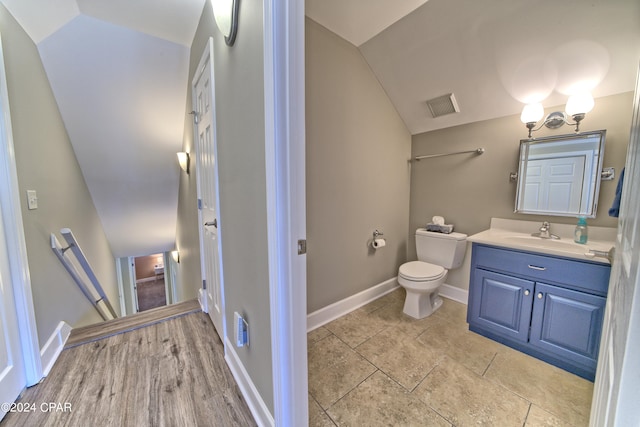 bathroom featuring lofted ceiling, wood-type flooring, vanity, and toilet