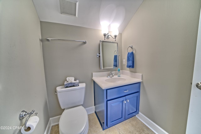 bathroom featuring toilet, vanity, and tile patterned flooring