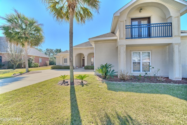 view of front facade with a balcony and a front yard