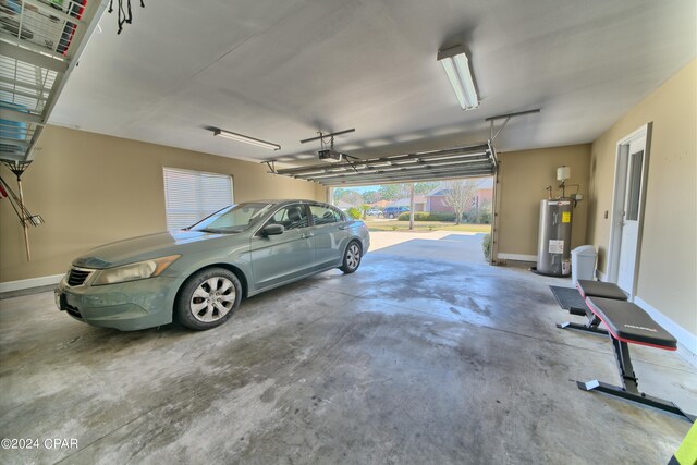 garage with electric water heater, a carport, and a garage door opener