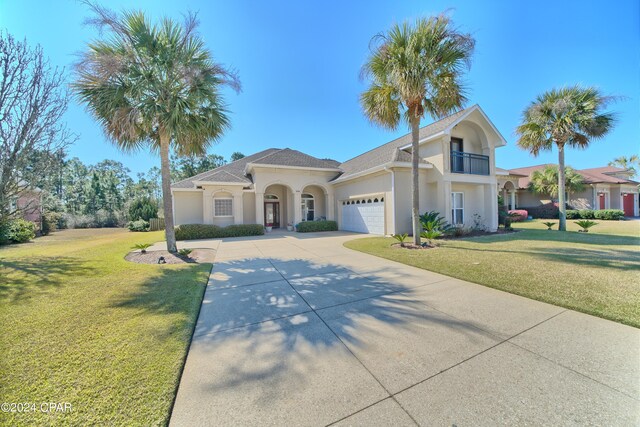 view of front of home with a front lawn, a balcony, and a garage