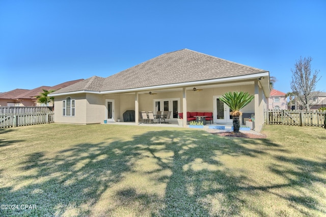 rear view of house with a yard, french doors, a fenced backyard, and ceiling fan