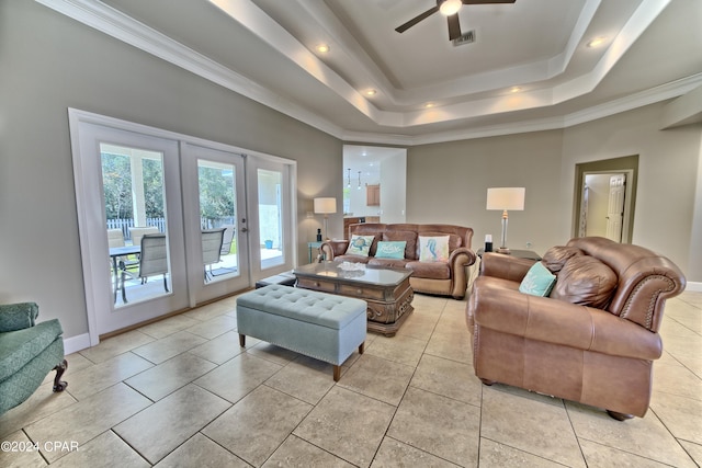 living room featuring ceiling fan, light tile patterned flooring, a tray ceiling, and crown molding