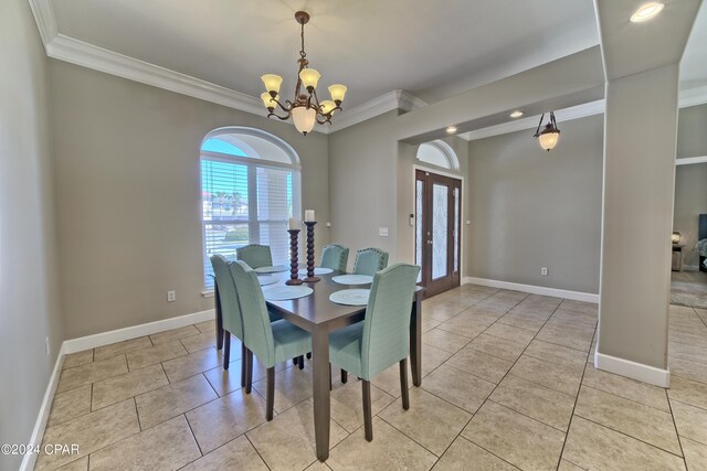 dining area with ornamental molding, light tile patterned floors, and an inviting chandelier