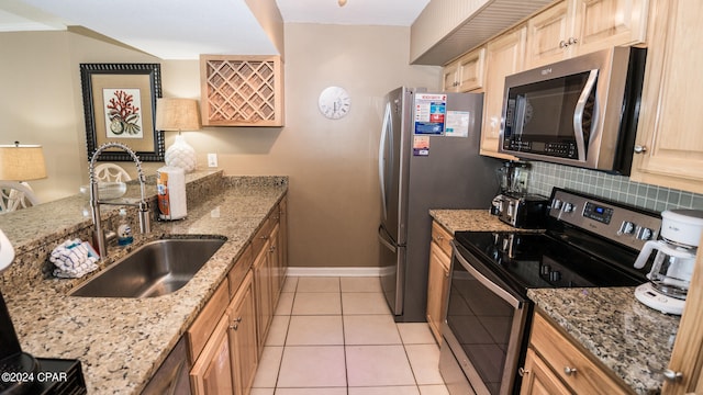 kitchen featuring light stone countertops, sink, stainless steel appliances, light tile floors, and tasteful backsplash