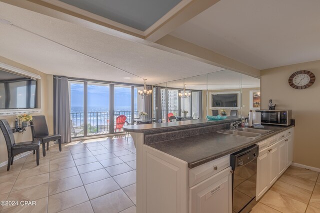 kitchen with a chandelier, black dishwasher, white cabinetry, and sink