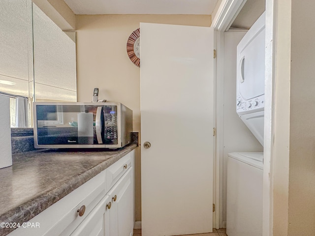 clothes washing area with stacked washer / dryer