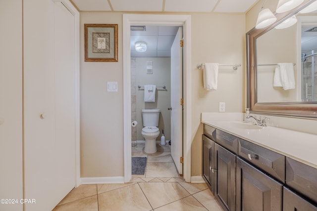 bathroom featuring tile patterned flooring, a paneled ceiling, vanity, and toilet