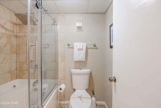 bathroom with toilet and bath / shower combo with glass door