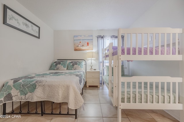 bedroom featuring light tile patterned floors and a textured ceiling