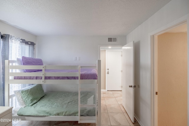 unfurnished bedroom with light tile patterned floors and a textured ceiling