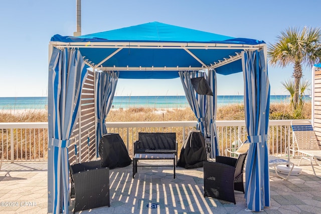 view of patio / terrace featuring a water view and a view of the beach