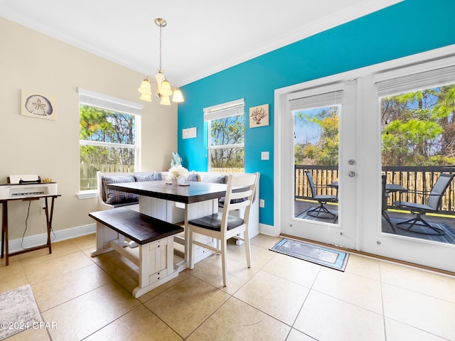 dining space featuring a notable chandelier, crown molding, and light tile flooring