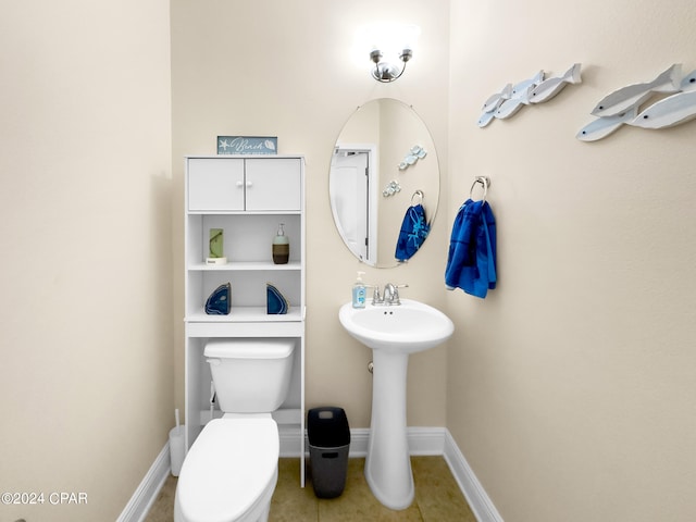 bathroom with toilet, tile flooring, and sink