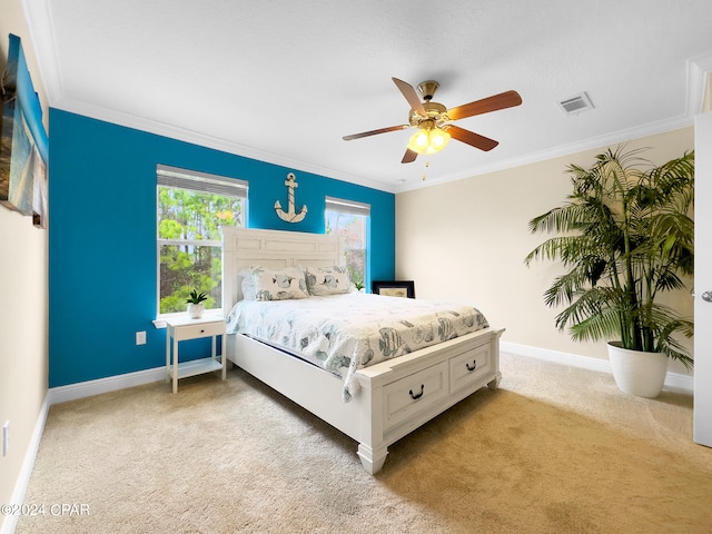 carpeted bedroom with ceiling fan and ornamental molding