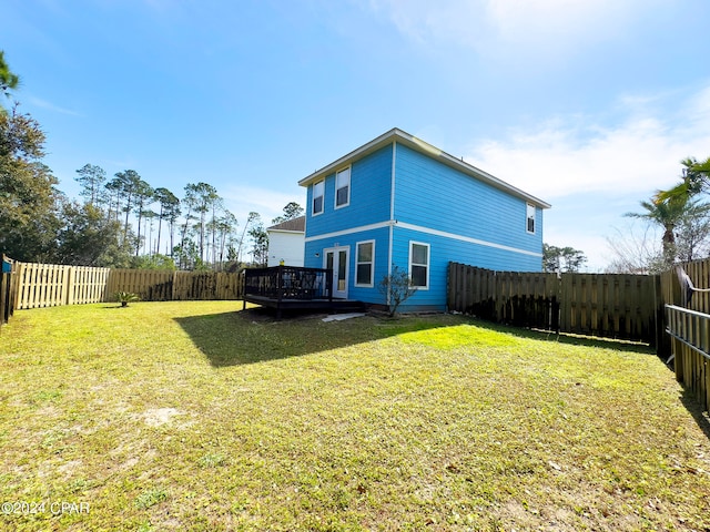 rear view of house featuring a yard and a deck