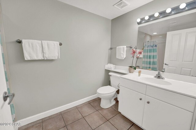 bathroom with toilet, vanity with extensive cabinet space, and tile flooring