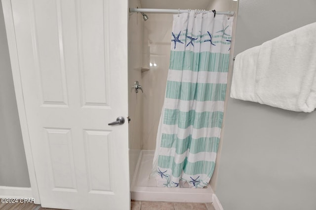 bathroom with tile floors and a shower with shower curtain