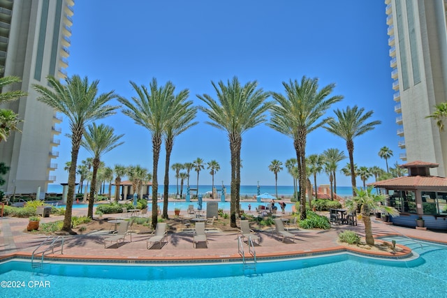 view of pool featuring a water view and a patio area